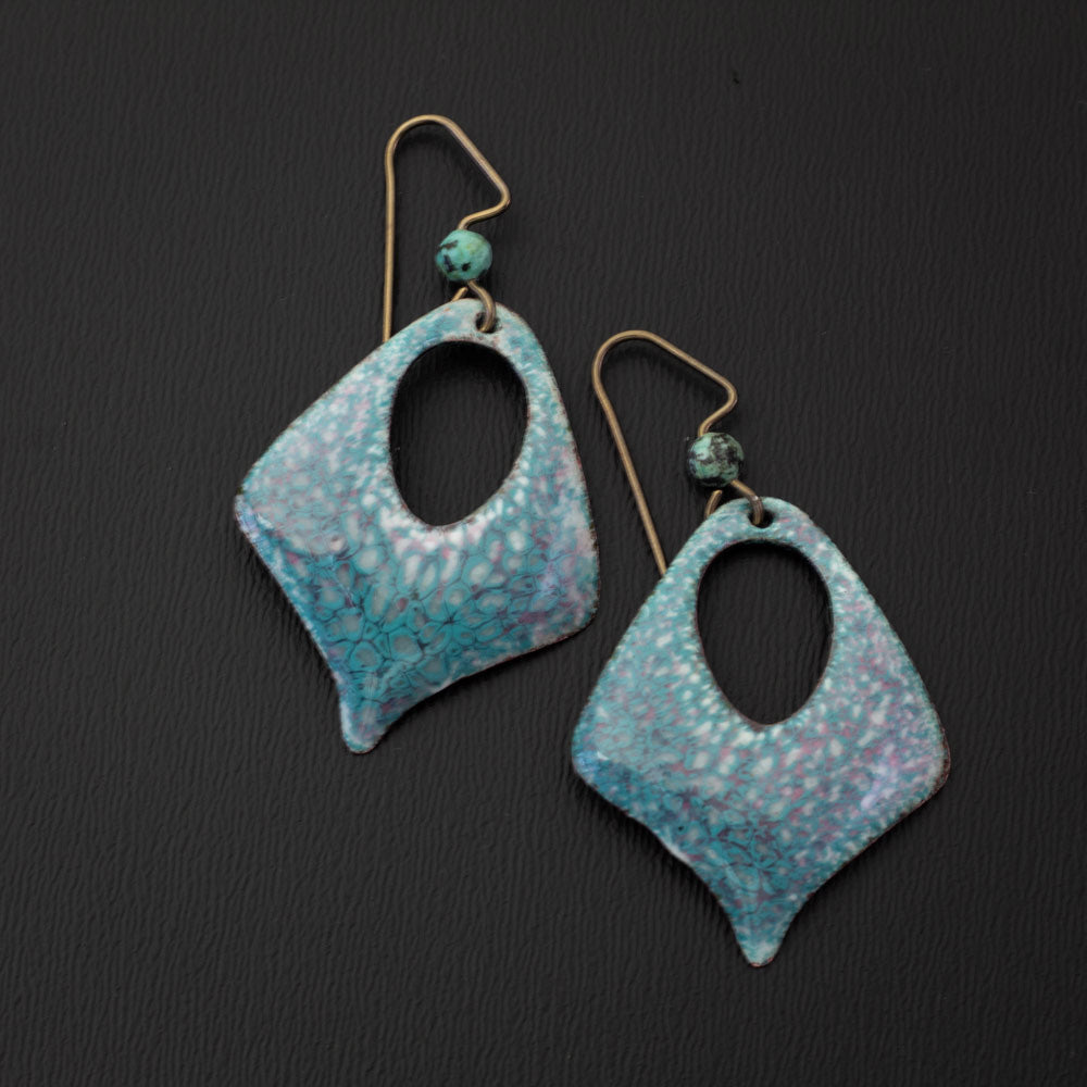 Pastel enamel earrings in soft sky blue and pink with a dappled crackle texture, diamond shape cutout design, handcrafted with niobium ear wires and matching blue gemstone accents.