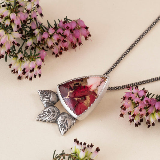 Sterling silver pendant necklace with triangular red and pink dahlia jasper stone, accented by three sculpted silver leaves, handcrafted in a nature-inspired artisan design.