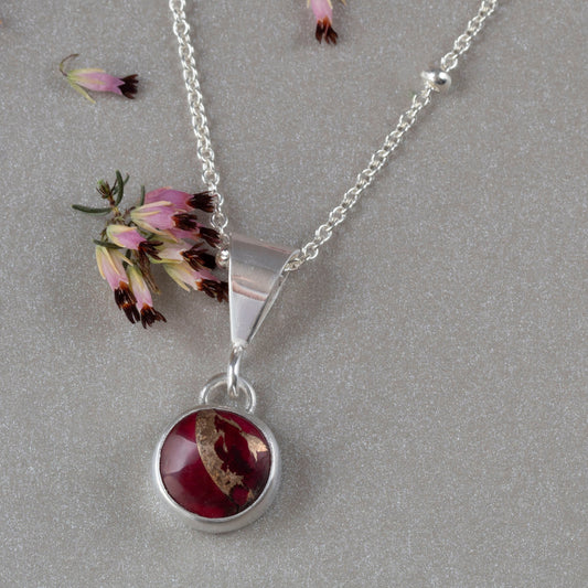 Dainty handmade sterling silver pendant necklace with round red and pink dahlia jasper stone, set on a fine chain with minimalist floral design and artisan elegance.”\