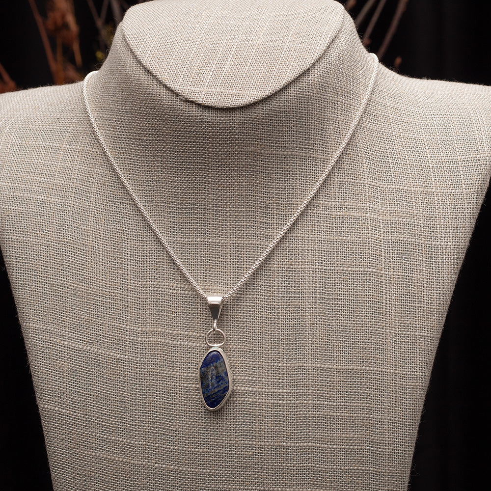 Sterling silver necklace with natural lapis lazuli pendant, set in a sleek bezel on an 18-inch chain, handmade by Divella Designs.