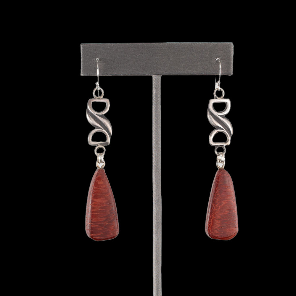 Handcrafted dangle earrings with deep red Bibingka wood teardrops and sculptural sterling silver links, modern artisan design displayed on black background – by Divella Designs