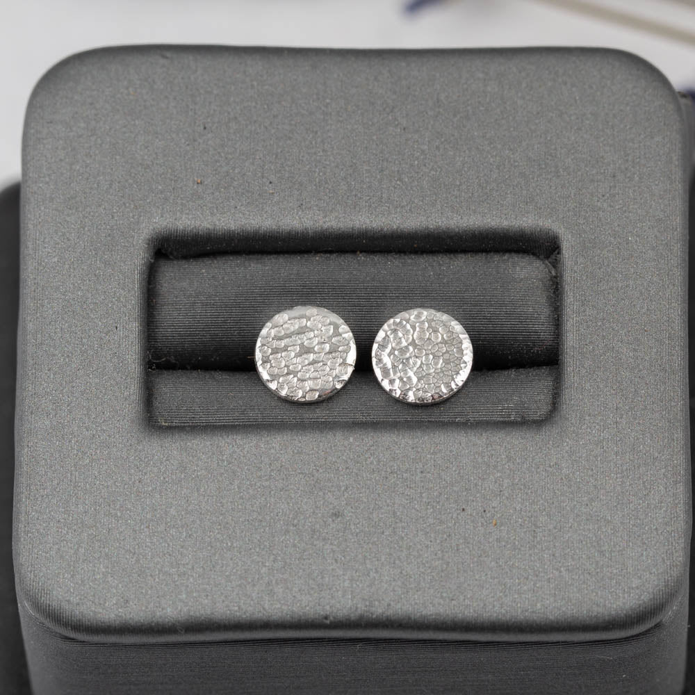 Silver round earrings in a gray jewelry box