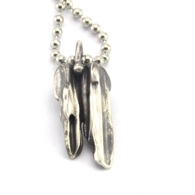 Close up of handmade broom-cast sterling silver necklace.