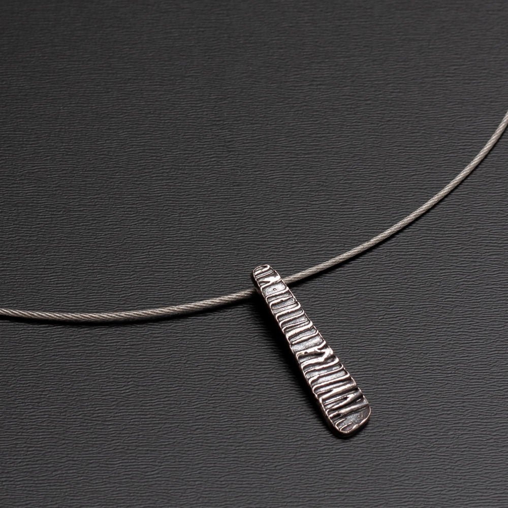 Sterling silver pendant with ripple texture on tapered form, reminiscent of water movement