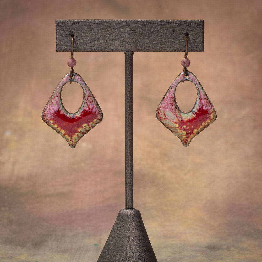 Handmade enamel earrings in pink and crimson with organic lace-like pattern, crafted on copper with niobium ear wires.