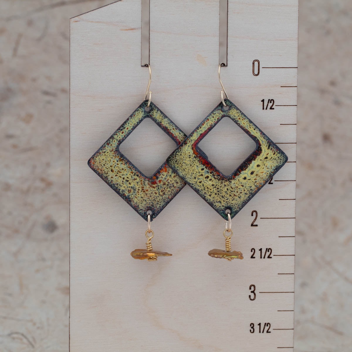 Yellow and red enamel openwork earrings shown for scale with airy center openings and golden keshi pearl drops.