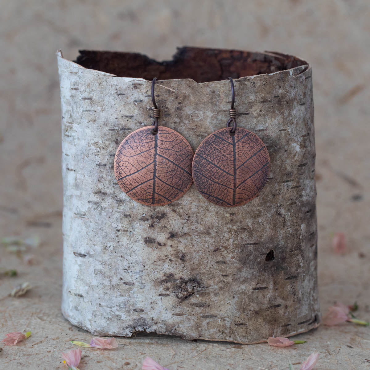 Handmade copper leaf print earrings with etched vein detail, featuring round disc shape and rustic botanical design inspired by nature