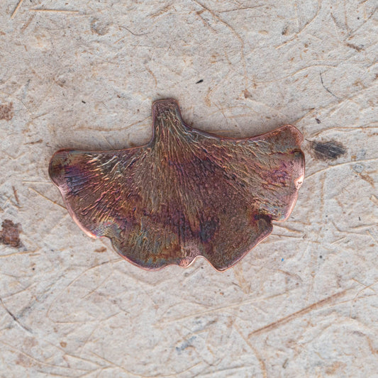 Handcrafted copper ginkgo leaf brooch with textured detail and organic fan shape, featuring nature-inspired botanical design and warm earthy patina.