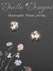 Sterling silver knot stud earrings displayed on a black Divella Designs card.