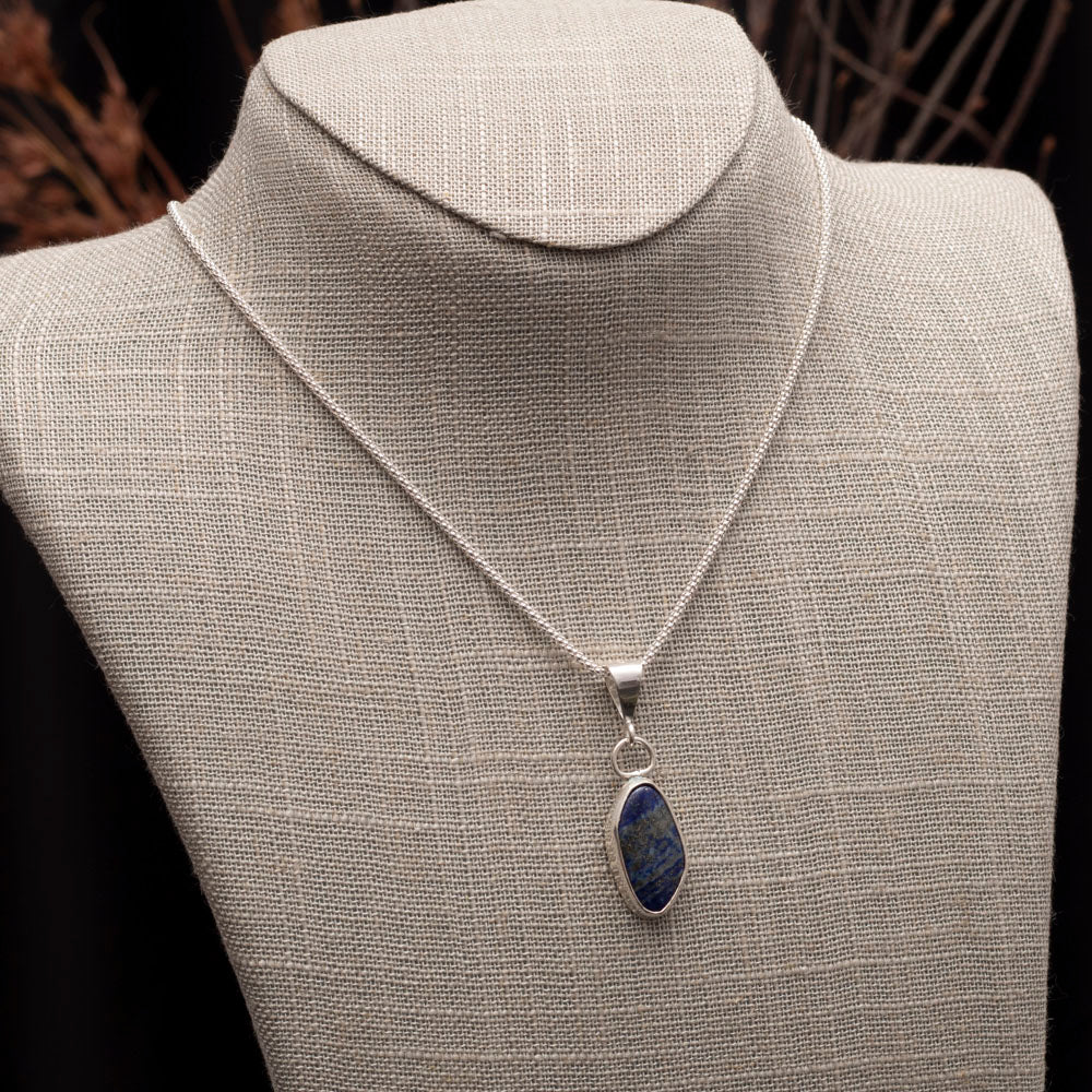 Sterling silver necklace with natural lapis lazuli pendant, set in a sleek bezel on an 18-inch chain, handmade by Divella Designs.
