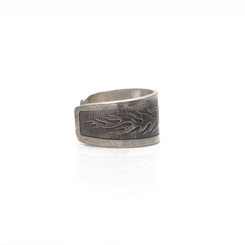 Side view of ear cuff with engraved flame motif and brushed finish