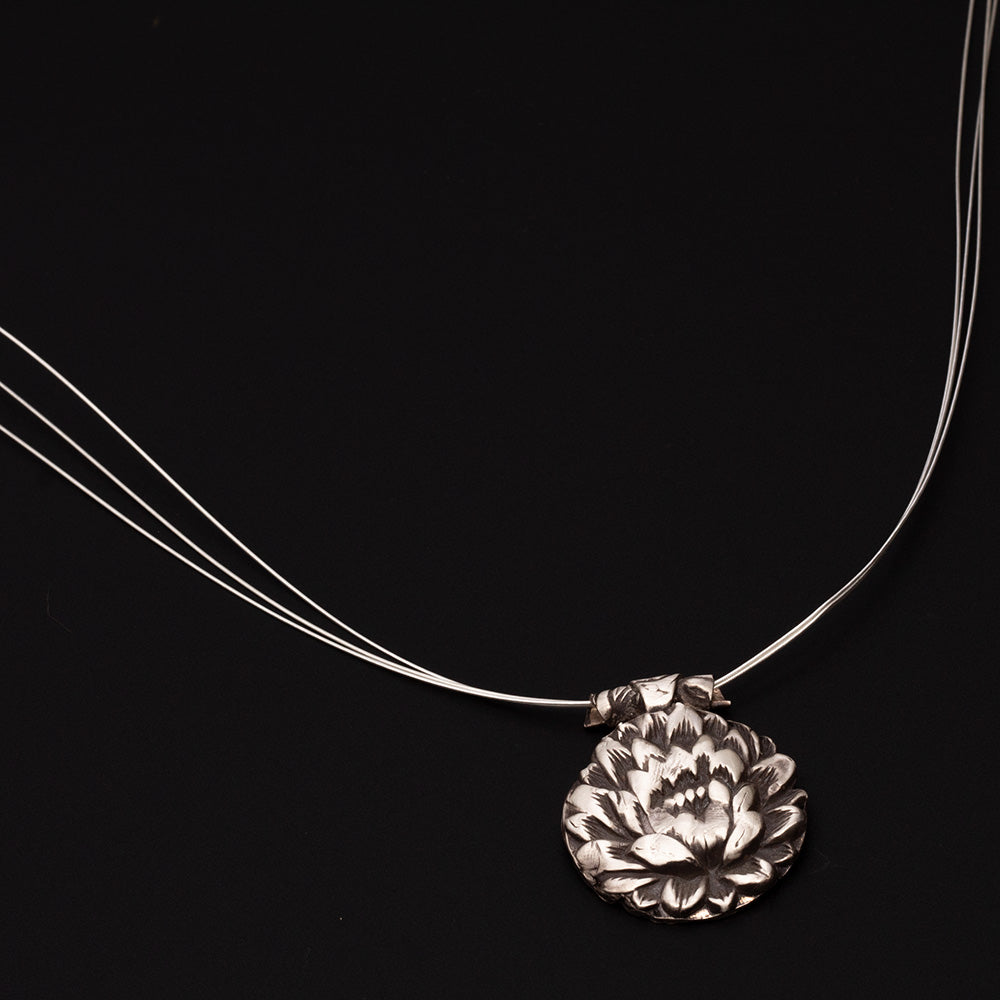 Fine silver lotus flower pendant on triple-strand sterling AccuFlex wire necklace.