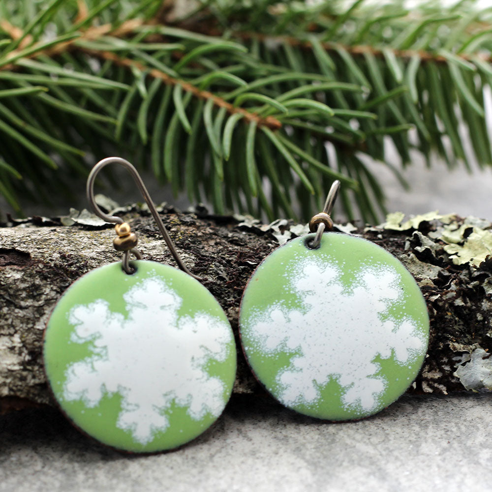 Green enamel earrings with white snowflake design and niobium ear wires