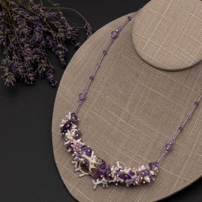Hand-beaded amethyst and pearl statement necklace with sculptural focal bead, styled on neutral bust  with dried lavender flowers
