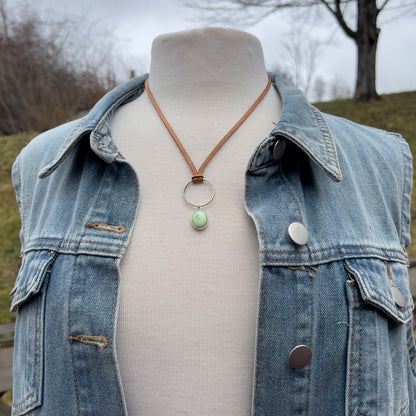 Mannequin wearing a denim jacket with a necklace featuring a variscite pendant.