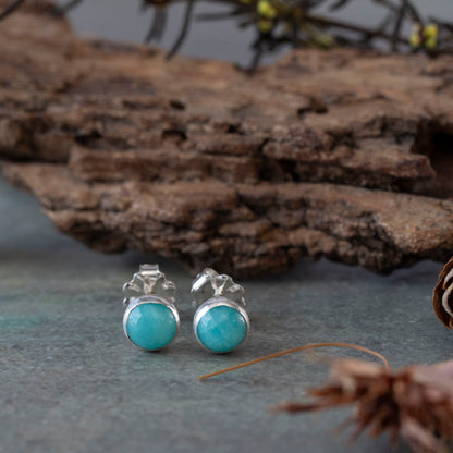 Amazonite and sterling silver stud earrings styled on slate with natural woodland elements.