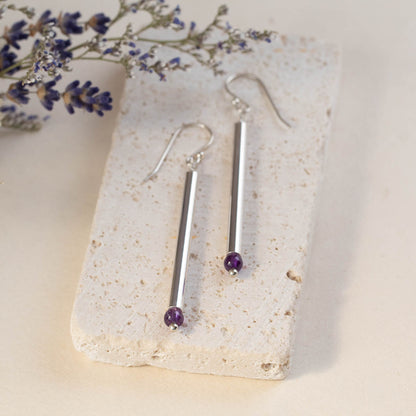 Handmade sterling silver drop earrings with long vertical bars and amethyst gemstones, featuring minimalist modern design and elegant artisan style.