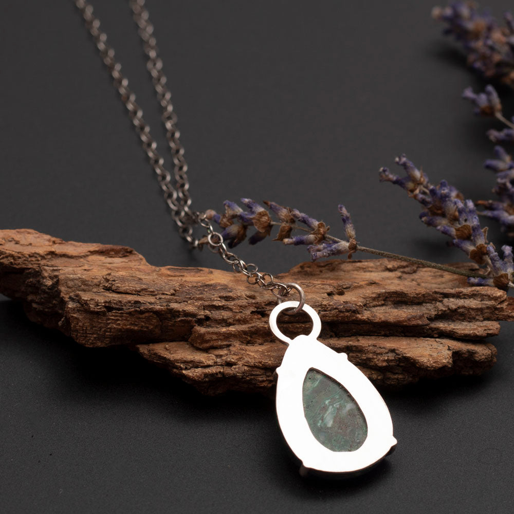 Back of teardrop-shaped green gemstone pendant with white inclusions on a sterling silver chain, handcrafted by Divella Designs.