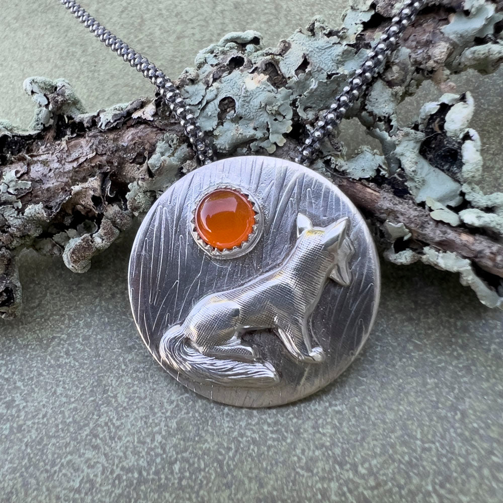 Sterling silver fox pendant with carnelian gemstone on lichen covered branch