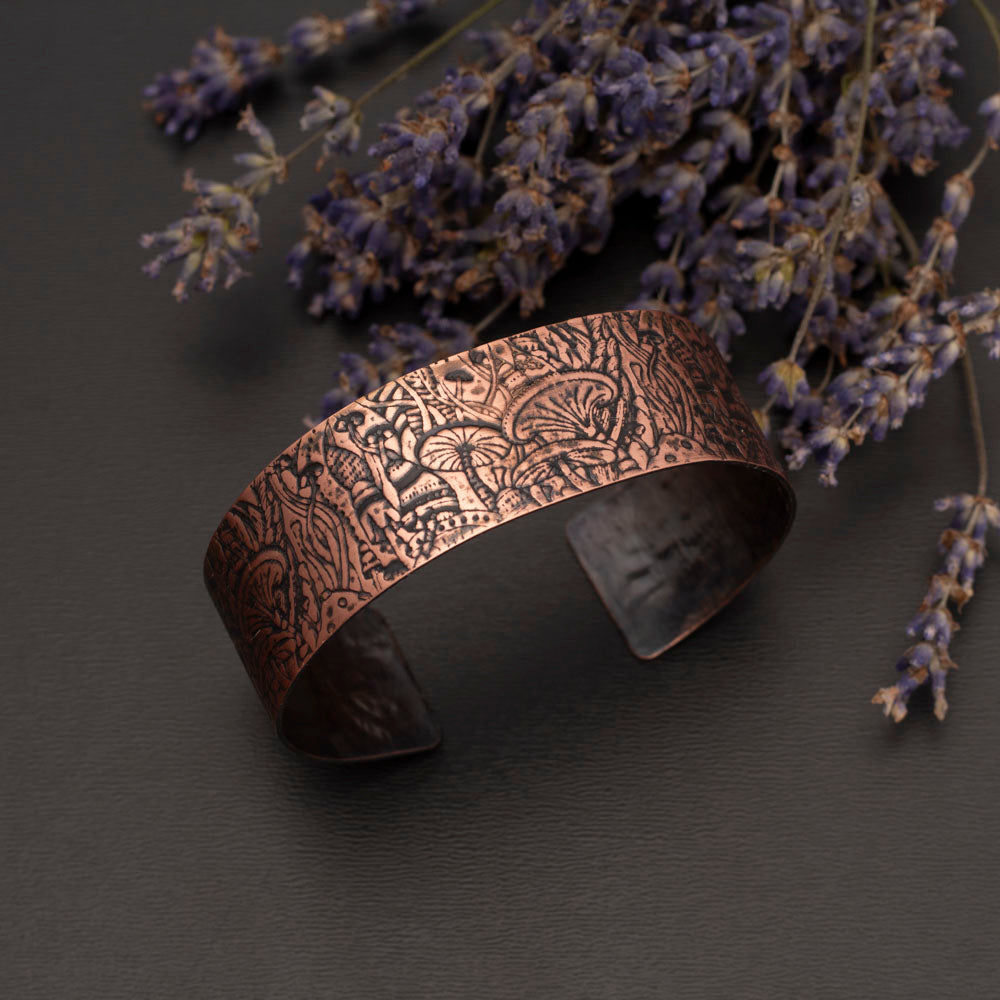Copper mushroom cuff bracelet with impressed fungi pattern, oxidized patina, and polished highlights, handmade in Vermont by Divella Designs.