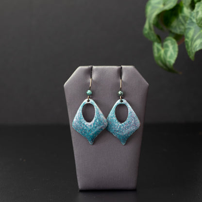 Pastel enamel earrings in soft sky blue and pink with a dappled crackle texture, diamond shape cutout design, handcrafted with niobium ear wires and matching blue gemstone accents.