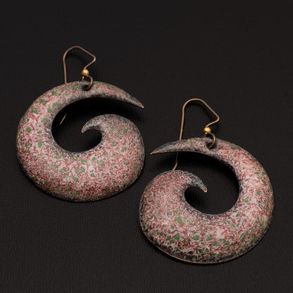 Large spiral enamel earrings in red, white, and green speckled pattern with a high-gloss finish, displayed on a black background with gold-filled ear wires.