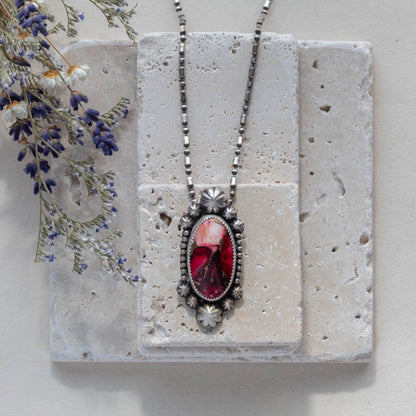 Handmade sterling silver pendant necklace featuring a red and pink dahlia jasper stone with floral accents, set in a decorative bezel on an oxidized beaded chain for a vintage botanical look.