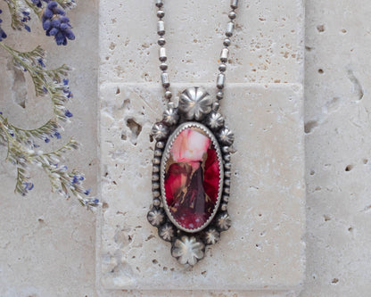 Handmade sterling silver pendant necklace featuring a red and pink dahlia jasper stone with floral accents, set in a decorative bezel on an oxidized beaded chain for a vintage botanical look.
