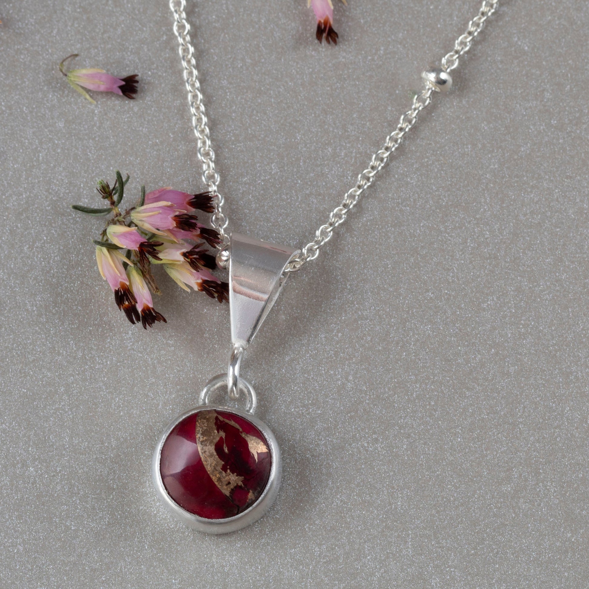 Dainty handmade sterling silver pendant necklace with round red and pink dahlia jasper stone, set on a fine chain with minimalist floral design and artisan elegance.”\