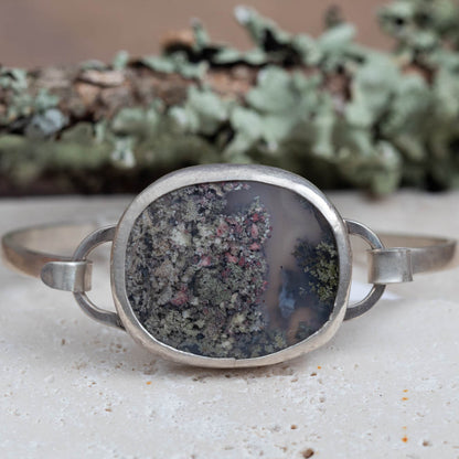 Dendritic agate sterling silver tension cuff bracelet with moss-like stone pattern and 6 1/2 inch oval cuff, handmade by Divella Designs in Vermont.