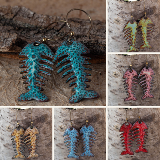 Fossil-style fishbone earrings in various colors displayed on a wooden background.