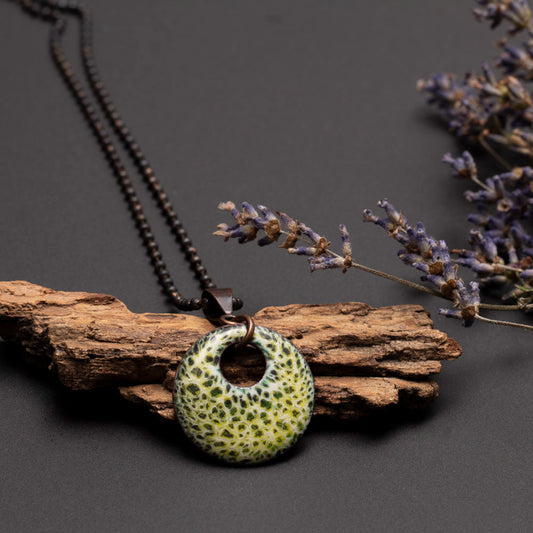 Round green enamel pendant necklace with speckled mossy texture on a 28-inch copper beaded chain, handmade by Divella Designs.