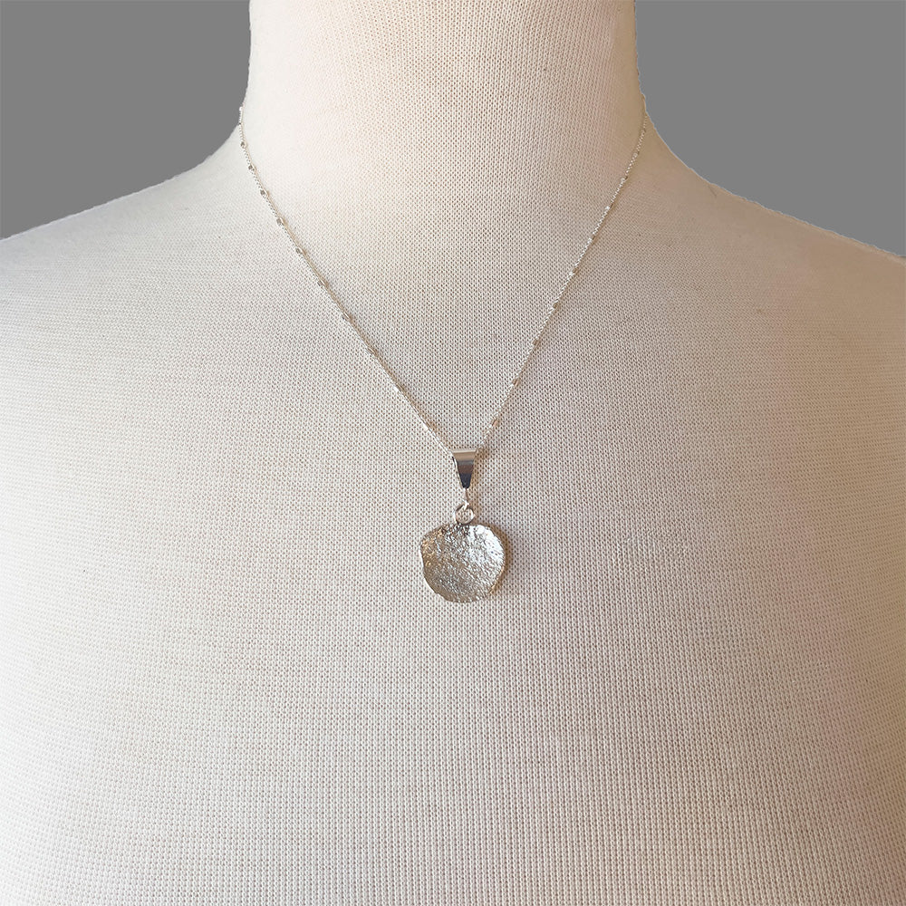 Fused silver dust necklace with organic lichen-like texture and sterling silver setting, handmade in Vermont by Divella Designs.