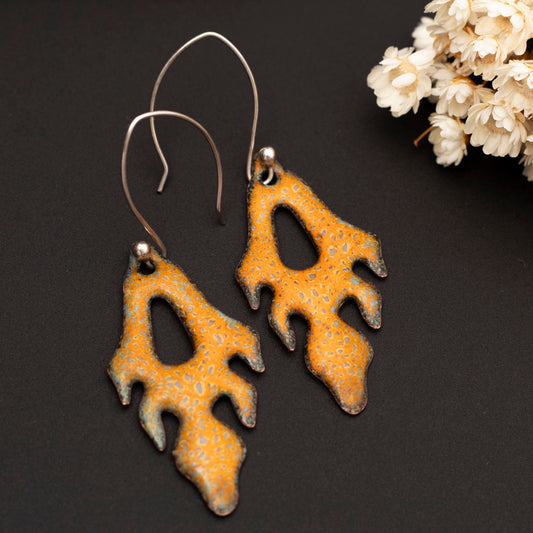 Handmade enamel copper earrings in golden yellow with organic frond-like design and sterling silver ear wires, bold botanical statement jewelry.