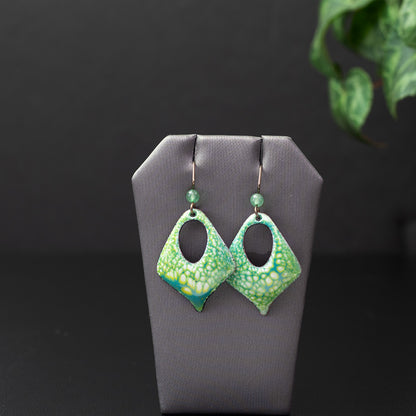 Handmade green enamel earrings with a botanical texture, diamond cutout shape, and niobium ear wires with green stone accents, inspired by forest foliage and spring growth.