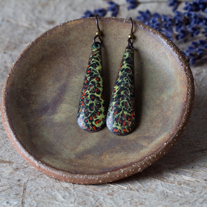 Green enamel teardrop earrings with dark organic texture, rusty orange details, and niobium ear wires.