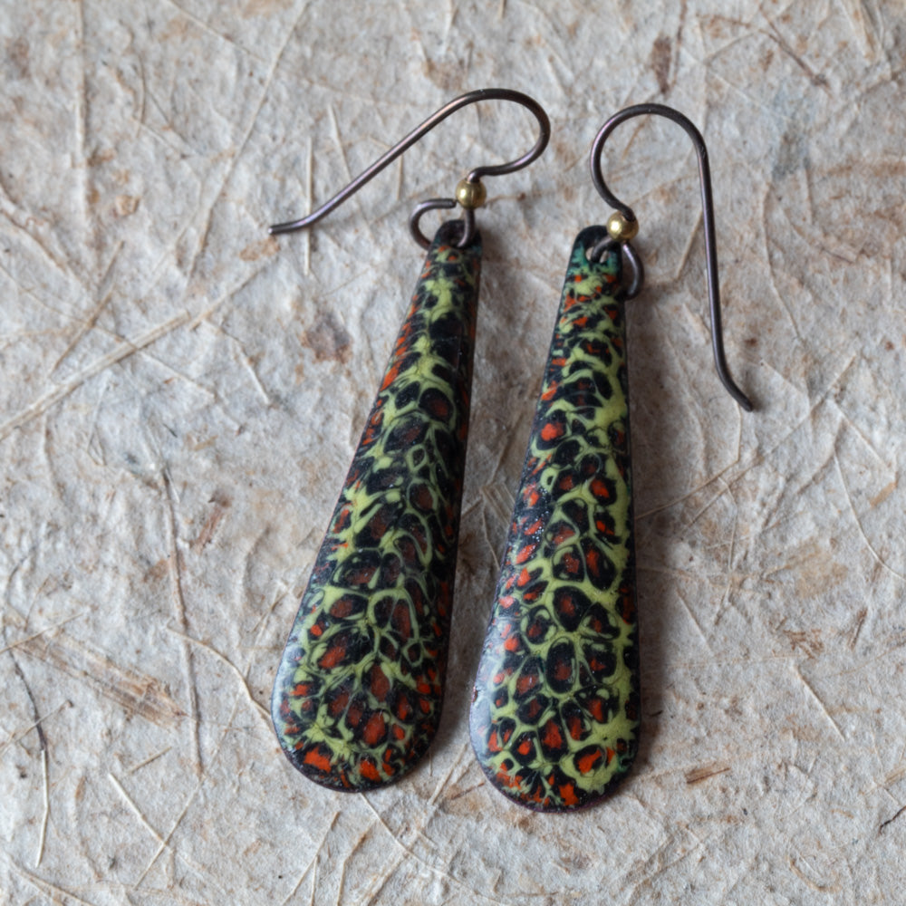 Green enamel teardrop earrings with dark organic texture, rusty orange details, and niobium ear wires.