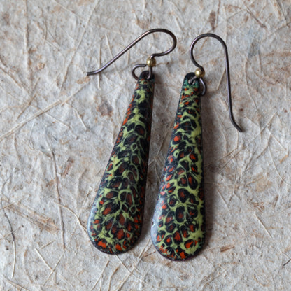 Green enamel teardrop earrings with dark organic texture, rusty orange details, and niobium ear wires.