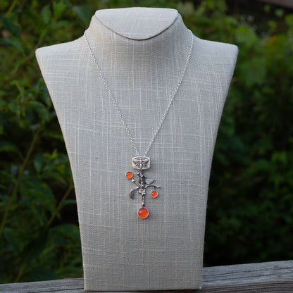 One-of-a-kind sterling silver branch pendant necklace with bee detail and bright carnelian stones displayed on a mannequin