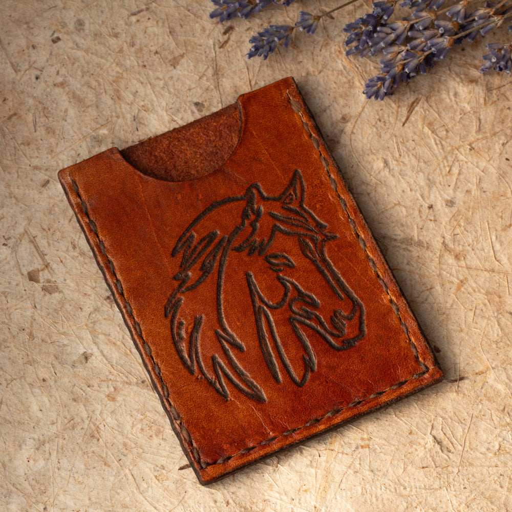 Handmade leather card case with embossed horse design. Compact size for cards or folded cash. Handmade in Vermont.