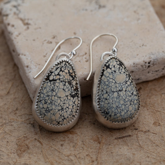 Ivory Creek Variscite teardrop earrings in sterling silver displayed on natural stone background.