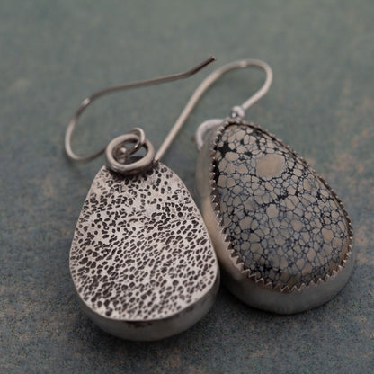 Close-up of handmade sterling silver earrings with Ivory Creek Variscite stones and textured silver backs