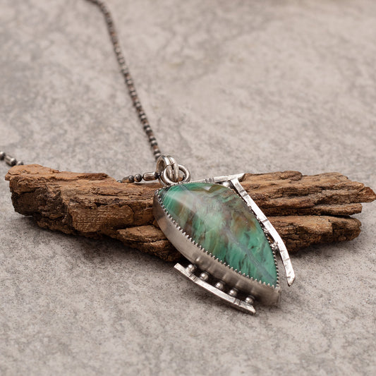 Handcrafted sterling silver pendant necklace featuring a green Kingman turquoise stone with modern geometric bezel setting on beaded chain.