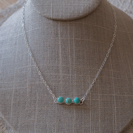 Kingman turquoise sterling silver necklace shown on a neutral linen necklace bust