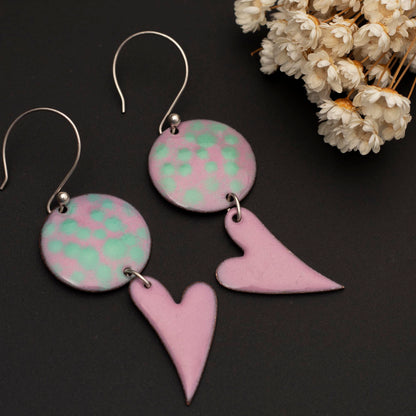 Handmade enamel heart dangle earrings in pink and mint green with sterling ear wires.