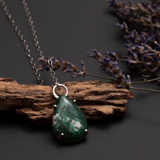 Teardrop-shaped green gemstone pendant with white inclusions on a sterling silver chain, handcrafted by Divella Designs.