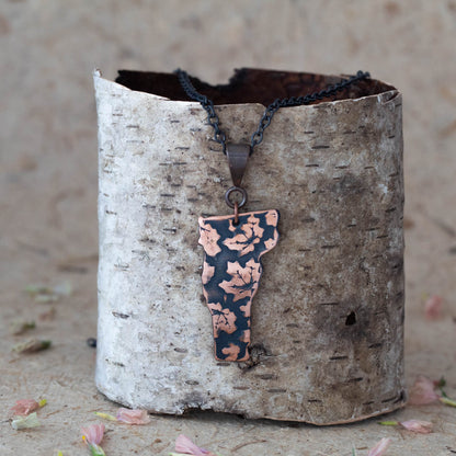 Handmade copper Vermont state pendant necklace with embossed maple leaf pattern and oxidized finish, featuring nature-inspired rustic design on black chain