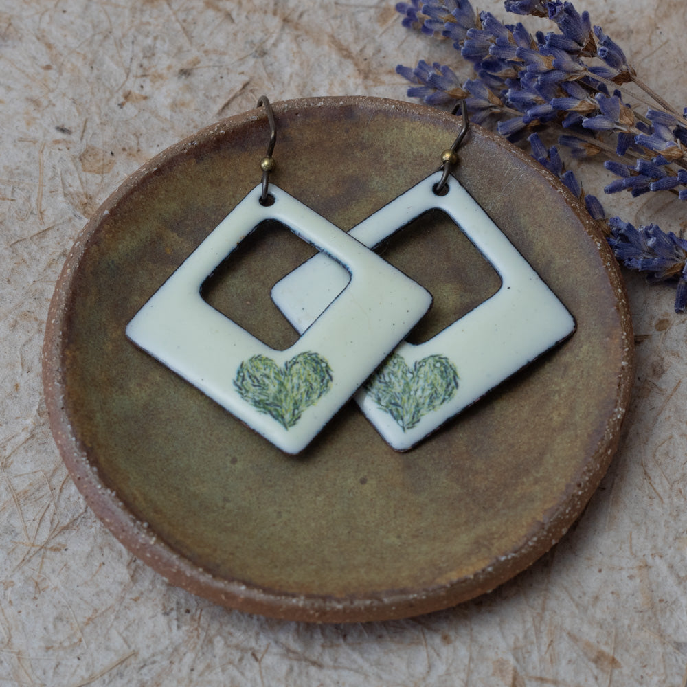Cream enamel open square earrings with green meadow heart design, handmade in Vermont.