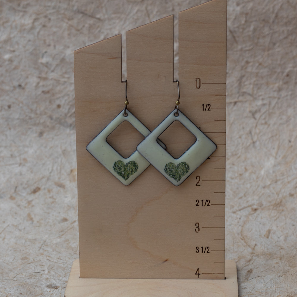 Cream enamel open square earrings with green meadow heart design, handmade in Vermont.