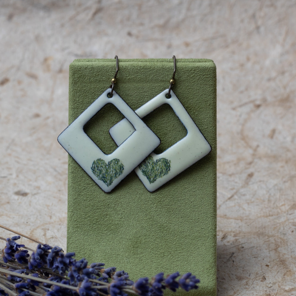 Cream enamel open square earrings with green meadow heart design, handmade in Vermont.